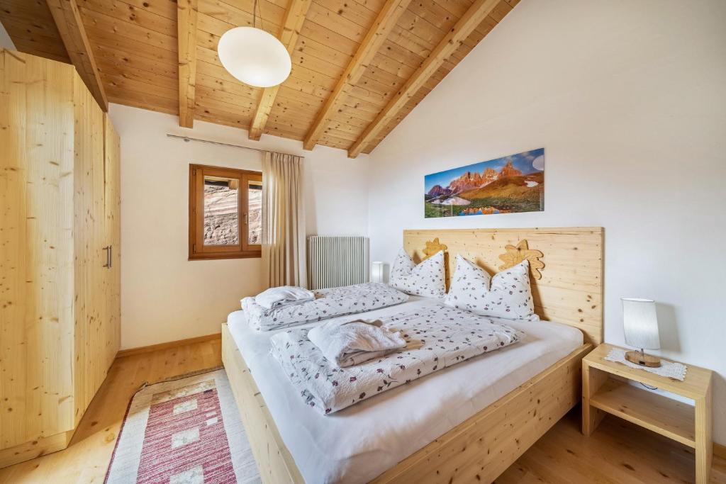 a bedroom with a large bed and a wooden ceiling at Eggerhof Familienparadies in Verano
