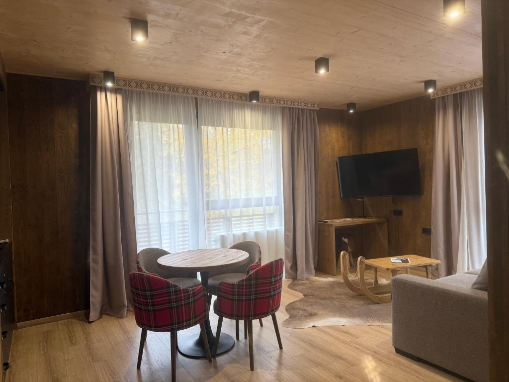 a living room with a table and chairs and a couch at Apartmán Forest, Tatranská Štrba in Tatranska Strba