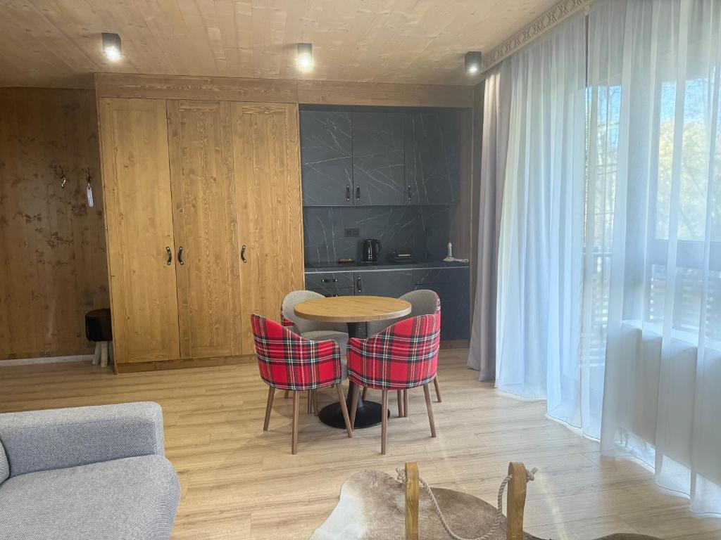 a living room with a table and red chairs at Apartmán Forest, Tatranská Štrba in Tatranska Strba