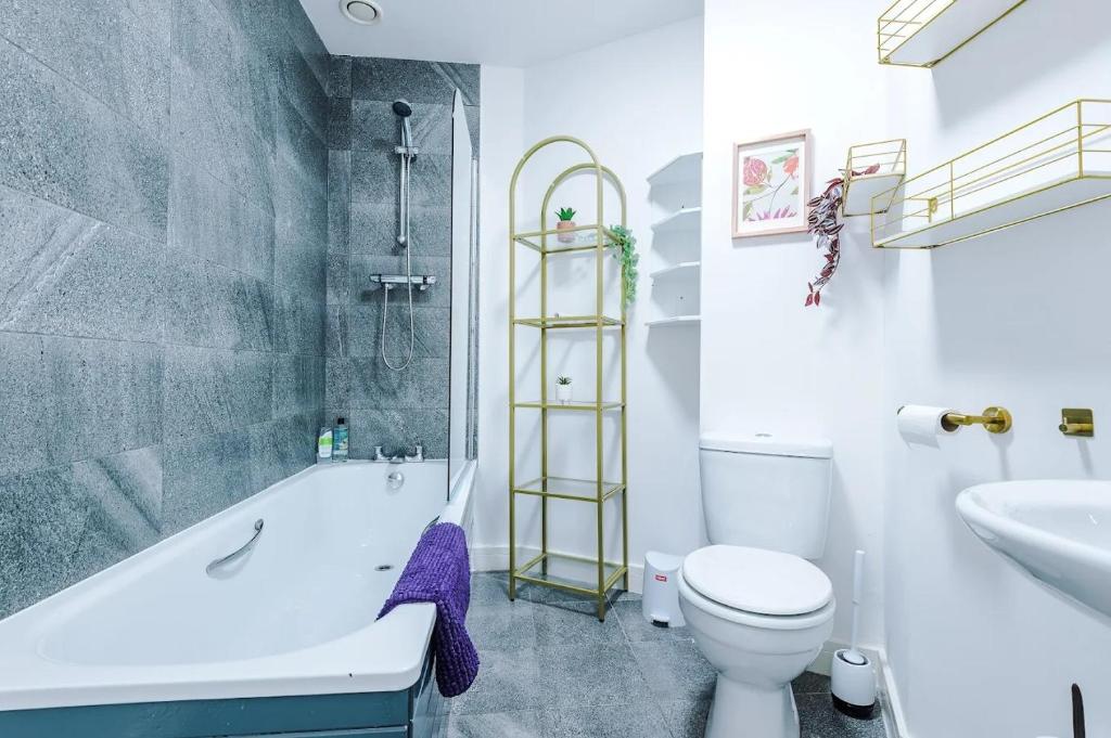 a bathroom with a tub and a toilet and a sink at Propti in Manchester