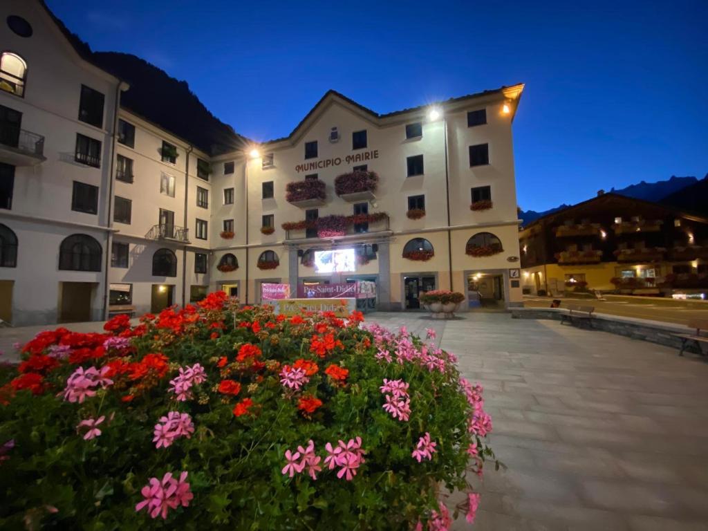 ein großes Gebäude mit Blumen davor in der Unterkunft Maison Maribel in Pré-Saint-Didier
