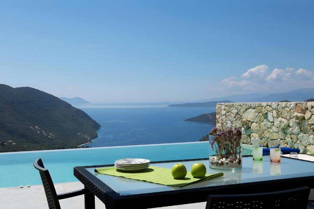 una mesa con comida y vistas al océano en Romantic Villa Gialos Over Mikros, en Fternón