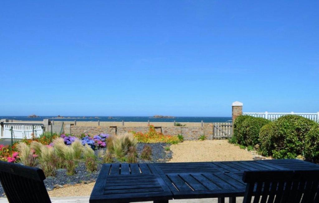 a picnic table with a view of the beach at Maison face mer accès direct plage in Plougasnou