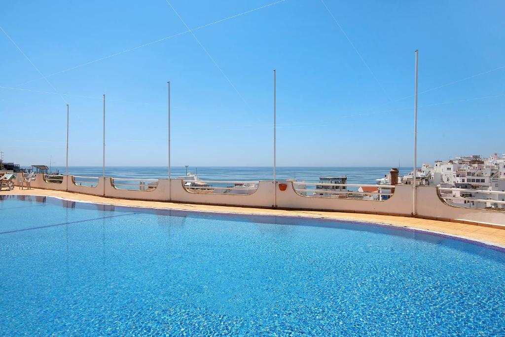 a swimming pool on a cruise ship with the ocean in the background at Paradis Bleu in Albufeira