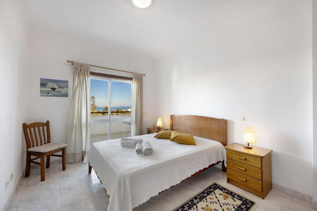 a bedroom with a bed and a chair and a window at Lagos Ocean View Apartment in Lagos