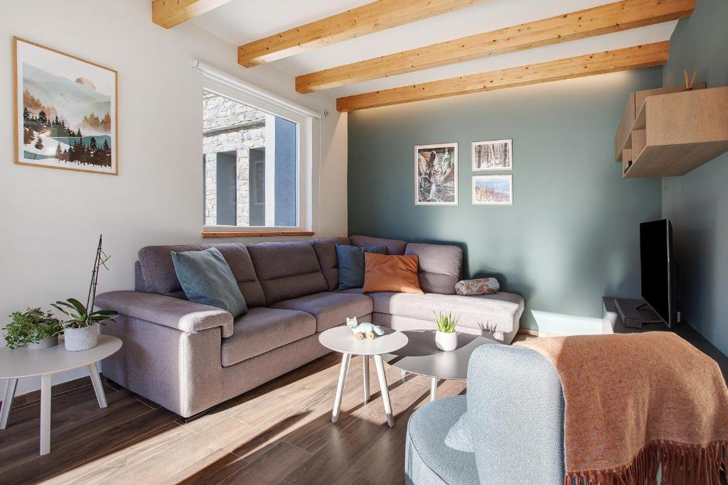 ein Wohnzimmer mit Couch und Tischen in der Unterkunft La Maison du Renard in Aosta