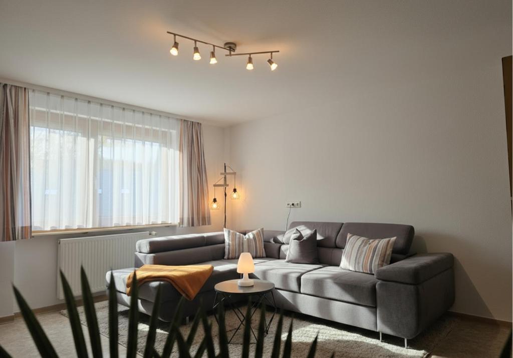 a living room with a couch and a table at Rückzugsort im Buhlbachtal Baiersbronn - Ferienwohnung mit beheiztem Wintergarten, Bergblick & Parkplatz in Baiersbronn