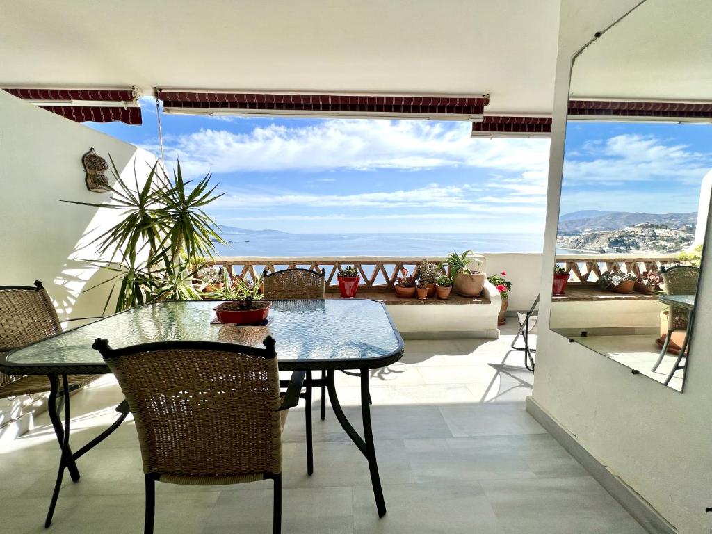 Una mesa y sillas en un balcón con vista. en Apartamento Cielo Azul, en La Herradura
