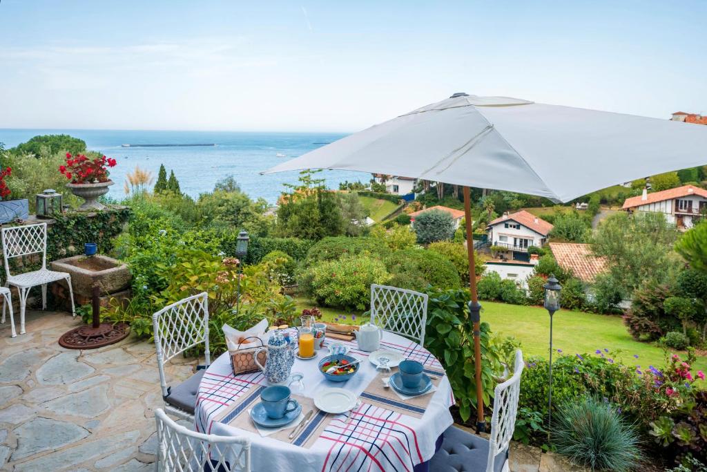 a table with an umbrella on a patio at L'annexe - Chambre in Ciboure