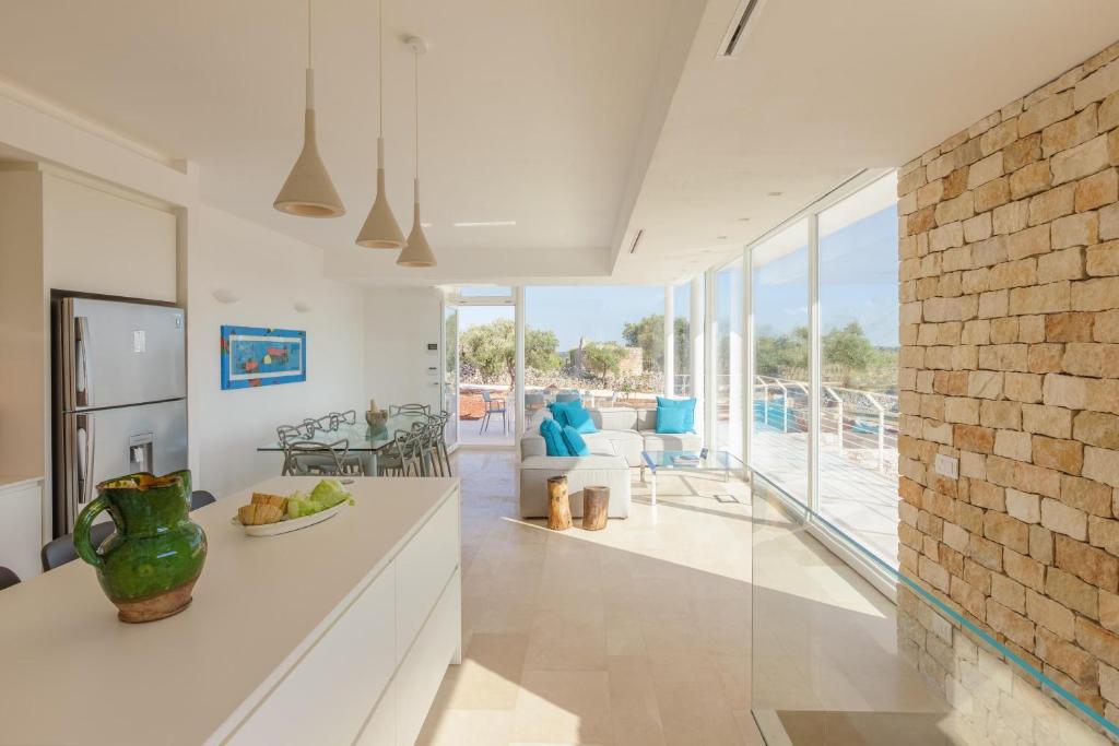 Il dispose d'une cuisine et d'un salon avec un mur en briques. dans l'établissement Villa Panitria, à Ostuni