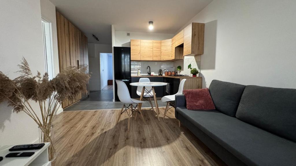 a living room with a couch and a table and a kitchen at Tabago Studio 37 Wodzisław in Wodzisław Śląski