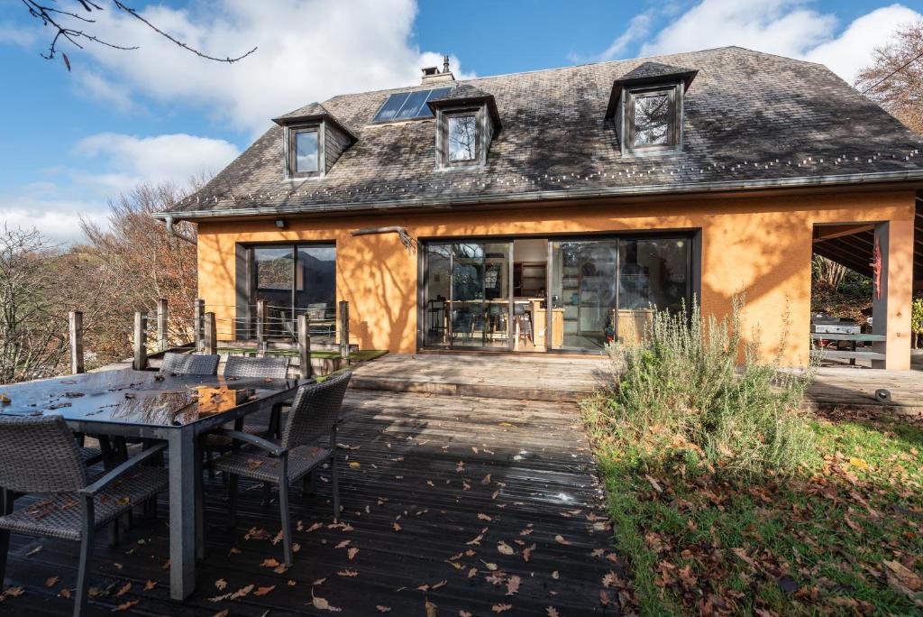 una casa vieja con una mesa delante en Maison Paul, en Bagnères-de-Bigorre