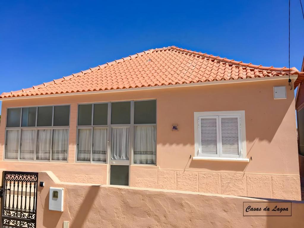 a pink house with a red roof at Encanto da Praia in Santo André