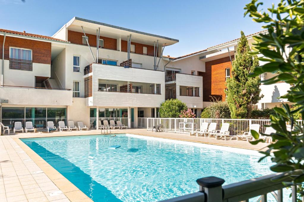 a swimming pool in front of a building at Appartement - Terrasses De L'Océan in Moliets-et-Maa