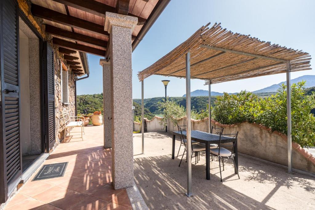 a patio with a table and chairs under a roof at casa Luna in Dorgali