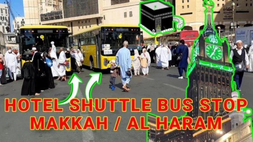 a group of people walking in a street with buses at Manasik Al Bait Hotel Makkah in Makkah