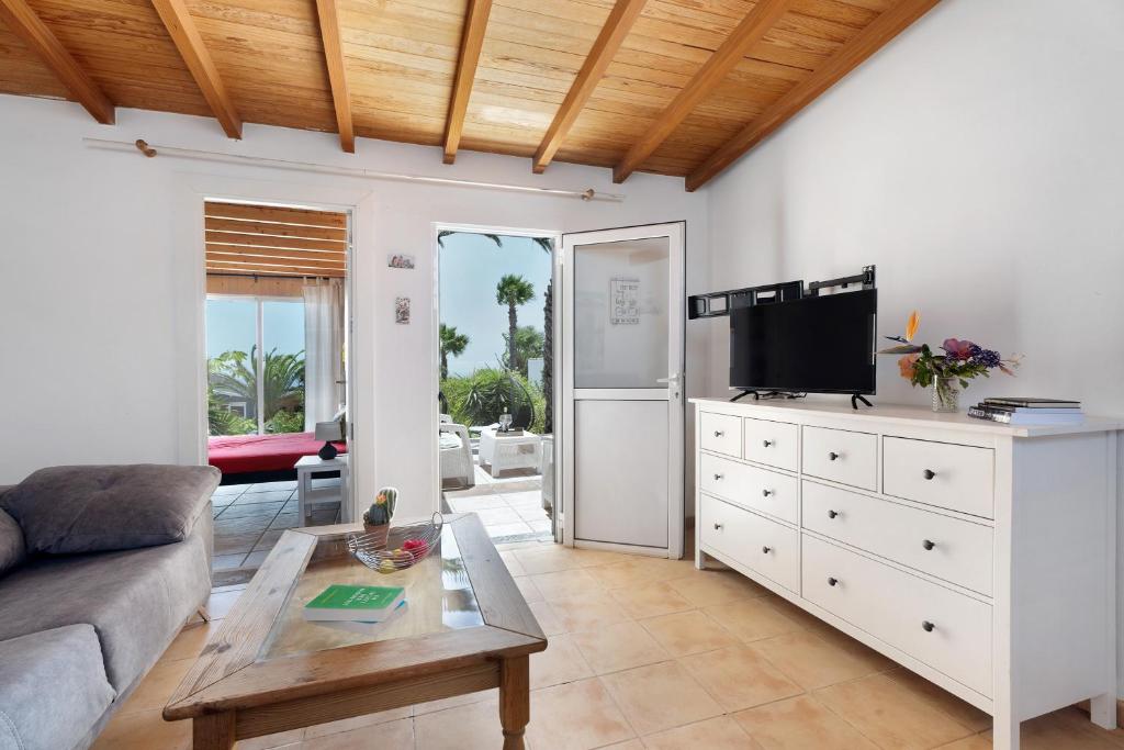 een woonkamer met een bank en een tv bij Finca Firmamento, Casa Sol in San Isidro