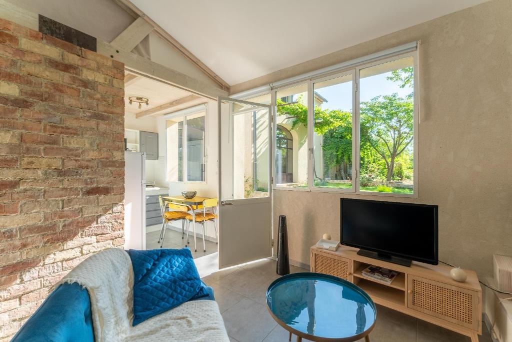 a living room with a couch and a tv at Studio à la campagne in Sarrians