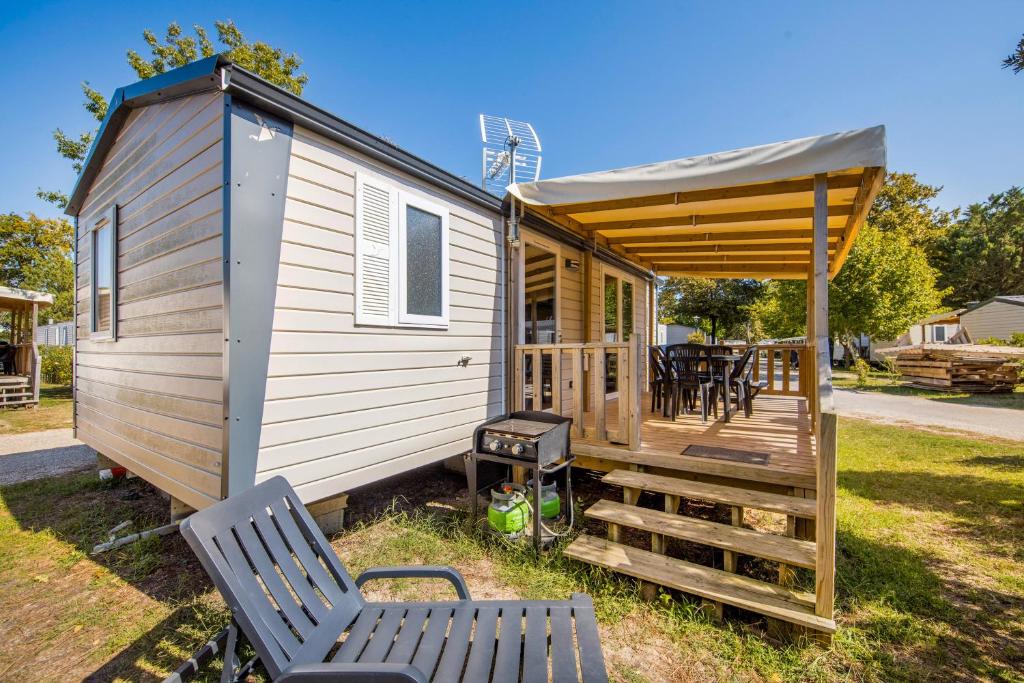 a tiny house with a porch and a table and chairs at Perle Des Iles - Cap-Ferret in Lège-Cap-Ferret