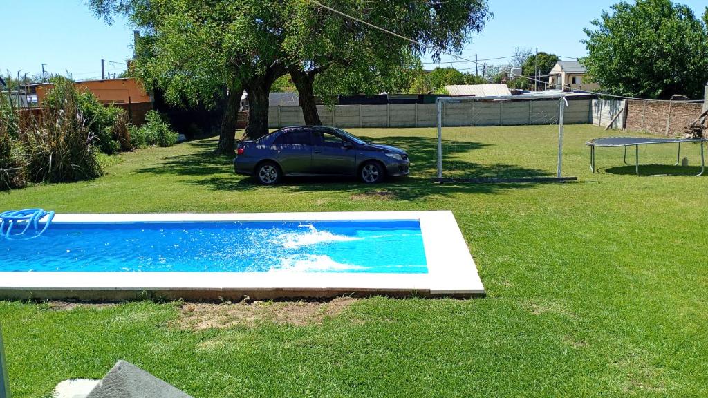 een auto geparkeerd in een tuin met een zwembad bij La Rosadita in Paraná