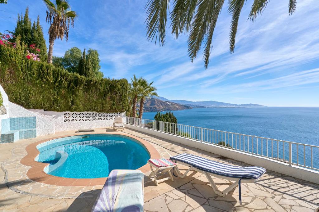 a swimming pool with a view of the ocean at El Nido in Almuñécar