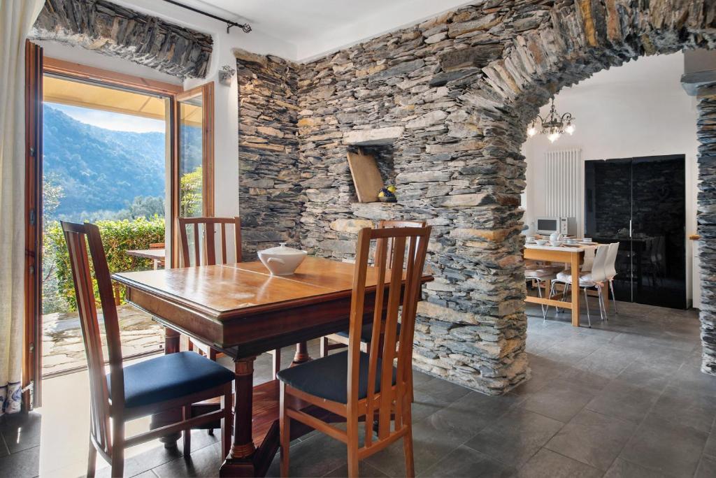 Un comedor con una mesa y una pared de piedra. en Ca' du Re, en Chiavari