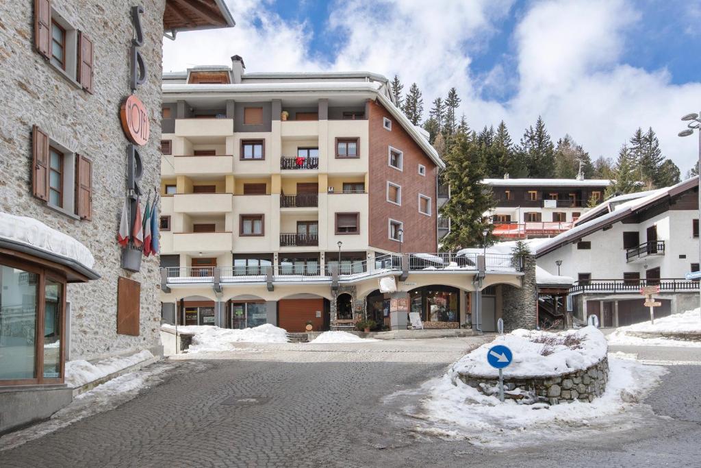 a snow covered street in front of a building at Appartamenti I Portici in Santa Caterina Valfurva