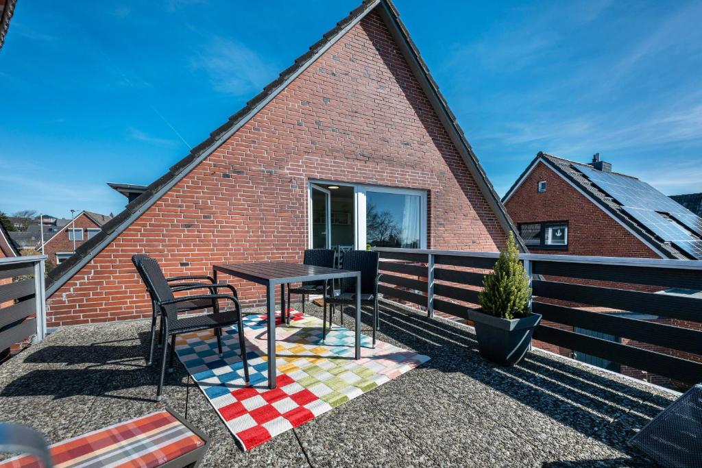 a patio with a table and chairs on a brick building at Ferienwohnung Am Wind in Bredstedt