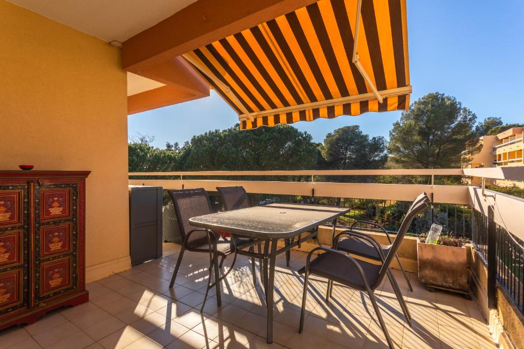 サン・ラファエルにあるAppartement Boulourisのバルコニーにテーブルと椅子が置かれたパティオ