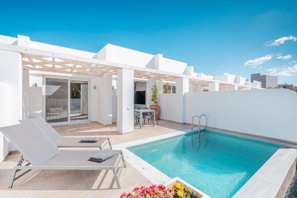 a white villa with a swimming pool and a patio at Punta Mare Villa 2 in Karpathos Town