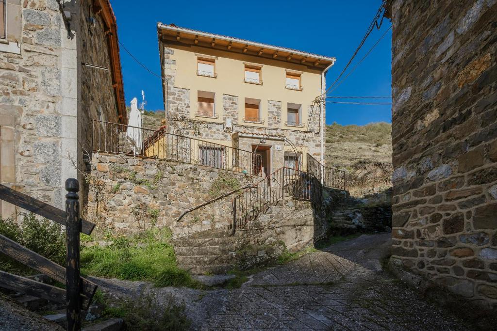 ein altes Steingebäude mit Treppen in einer Gasse in der Unterkunft La Casa De Sara in Llánaves de la Reina