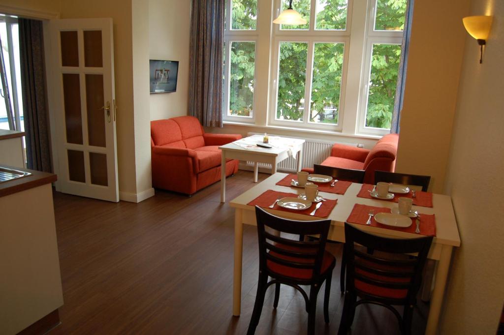 ein Wohnzimmer mit einem Tisch, Stühlen und einem Sofa in der Unterkunft Villa Paula in Bansin