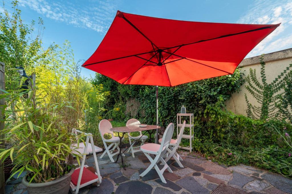 BrechにあるStudio dans maison proche gareの赤い傘付きテーブルと椅子