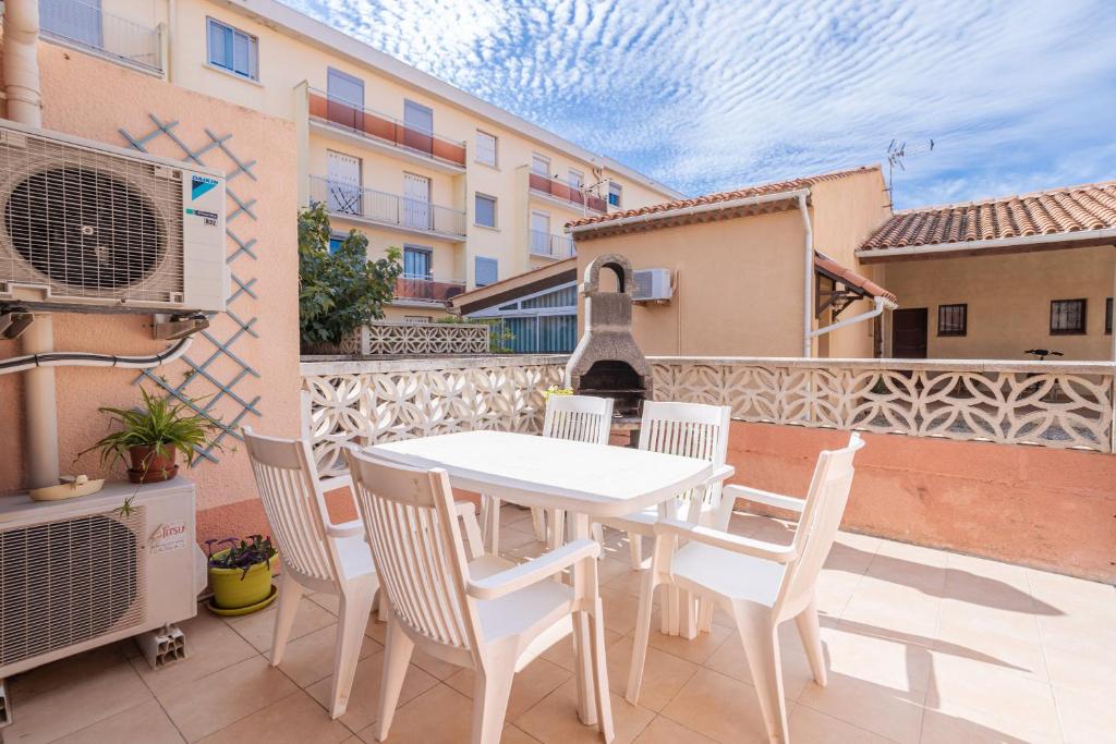 a white table and chairs on a balcony at Le Mieukerien - Réserve africaine 15 mn - Plage 200 m in Port-la-Nouvelle