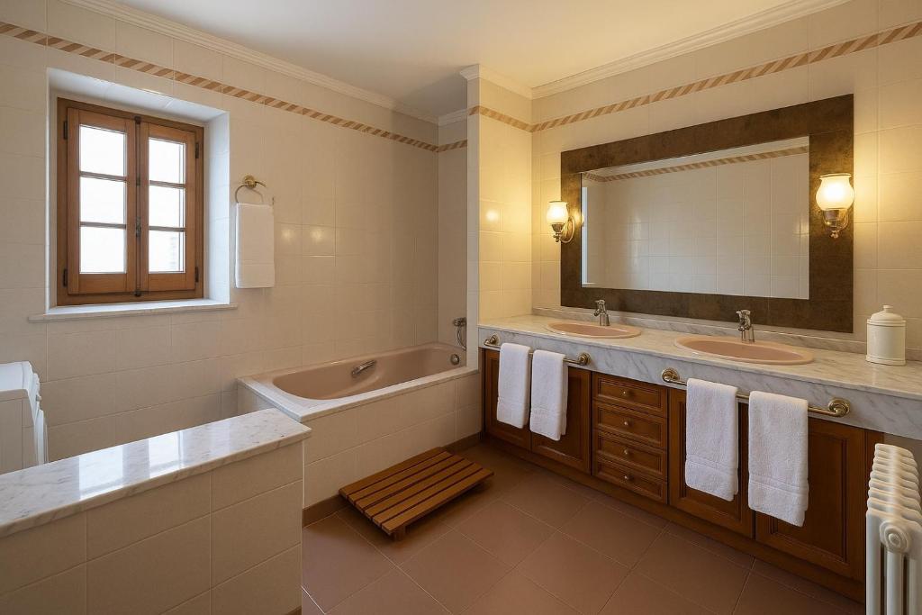 Un baño con dos lavabos, una bañera y un espejo. en Masia Can Cenç, en Collsuspina