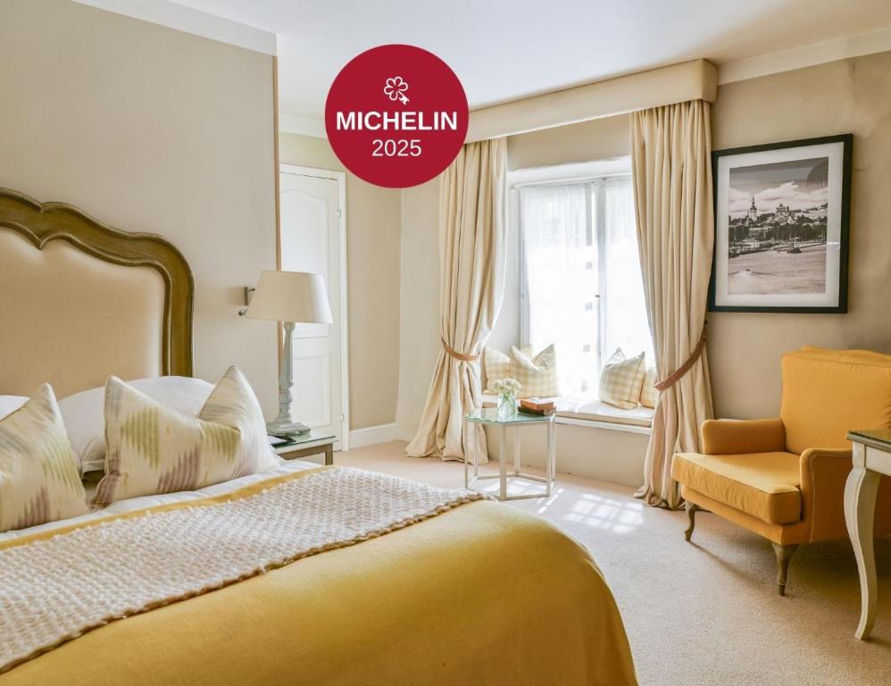 a bedroom with a yellow bed and a chair at Schlössle Hotel - Small Luxury Hotels of the World in Tallinn