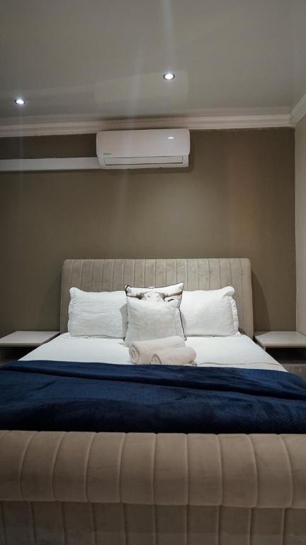 a bedroom with a large bed with white pillows at 3rd on Belgrave Guesthouse in Kimberley
