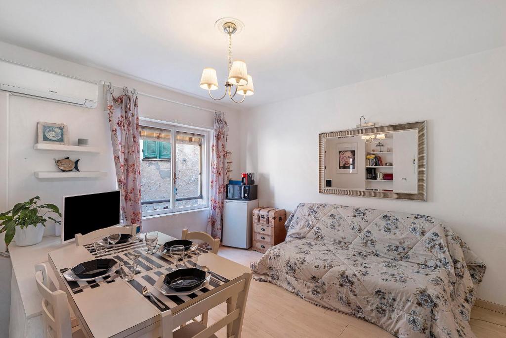 una sala de estar con un sofá y una mesa en La casa di Iris con posto auto, en Diano Marina