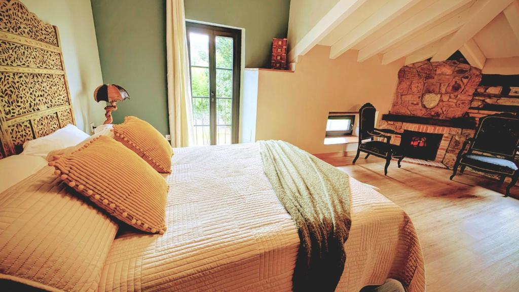 a bedroom with a large bed and a fireplace at Loft el Pasaje Secreto in Solórzano