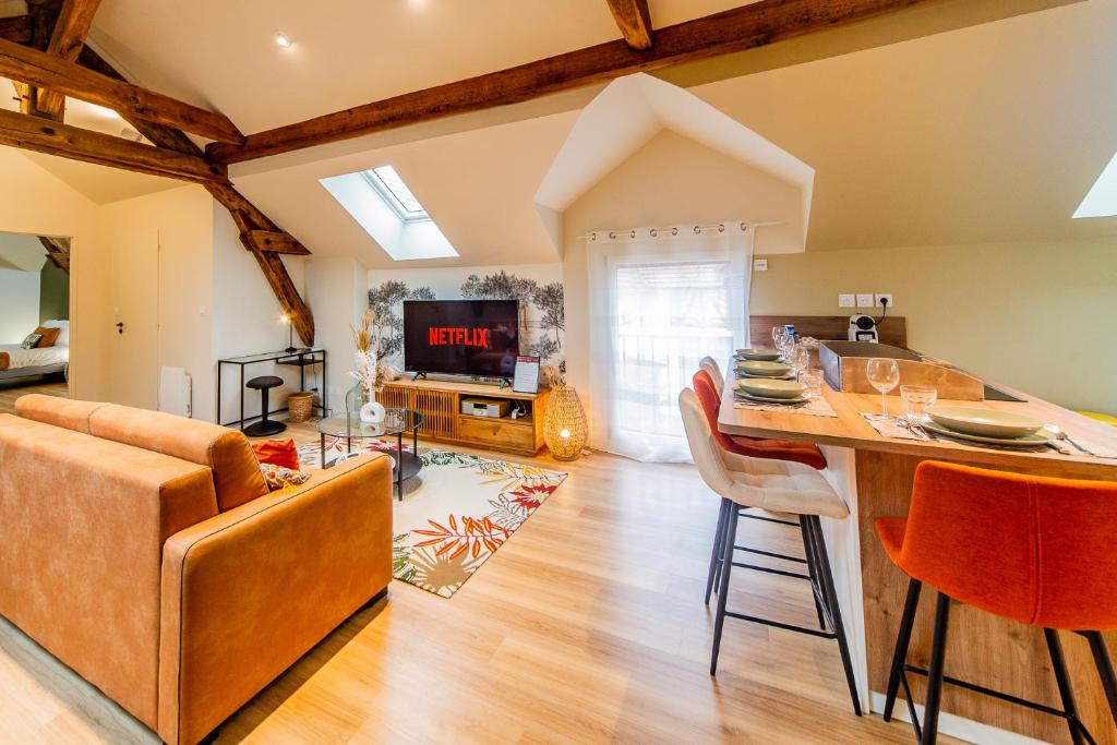 a kitchen and living room with a table and chairs at Le Céleste - Parking Privatif - Terrasse - Netflix in Ballan-Miré