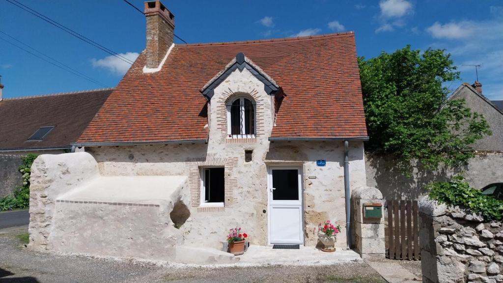 a small stone church with a white door at Gîte La Petite Maison in Huisseau-sur-Cosson