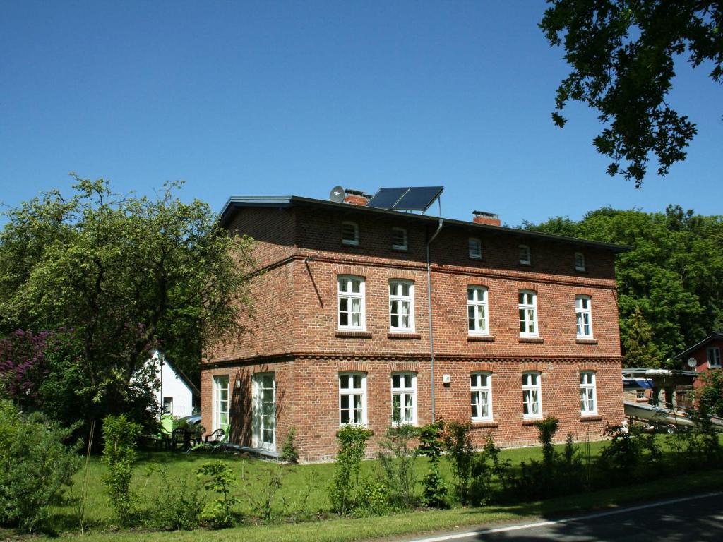 a large red brick building with a black roof at Eisenbahnerhaus Klausdorf in Klausdorf Mecklenburg Vorpommern