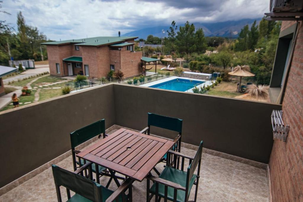 una mesa y sillas en un balcón con piscina en Soles de Belén, en Carpintería
