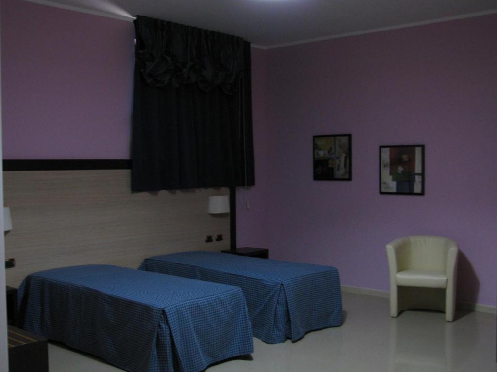 A bed or beds in a room at Albergo Roma