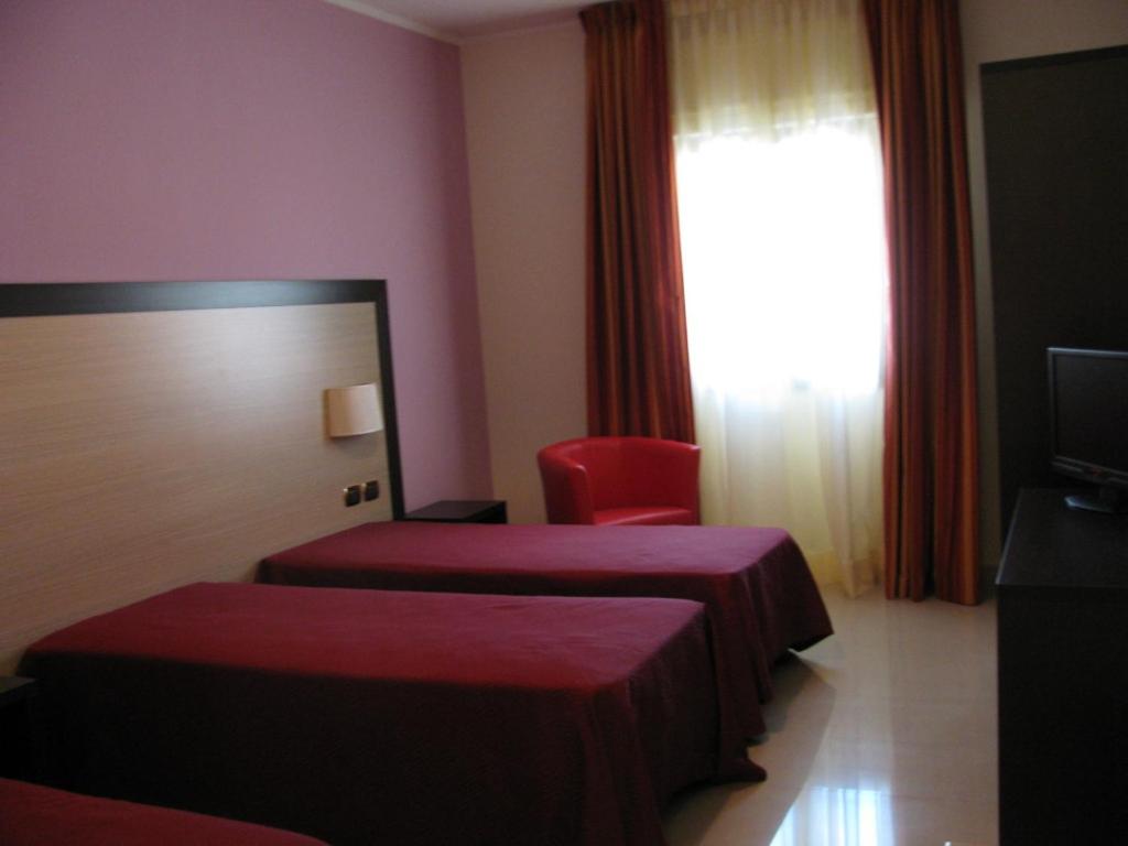 A bed or beds in a room at Albergo Roma