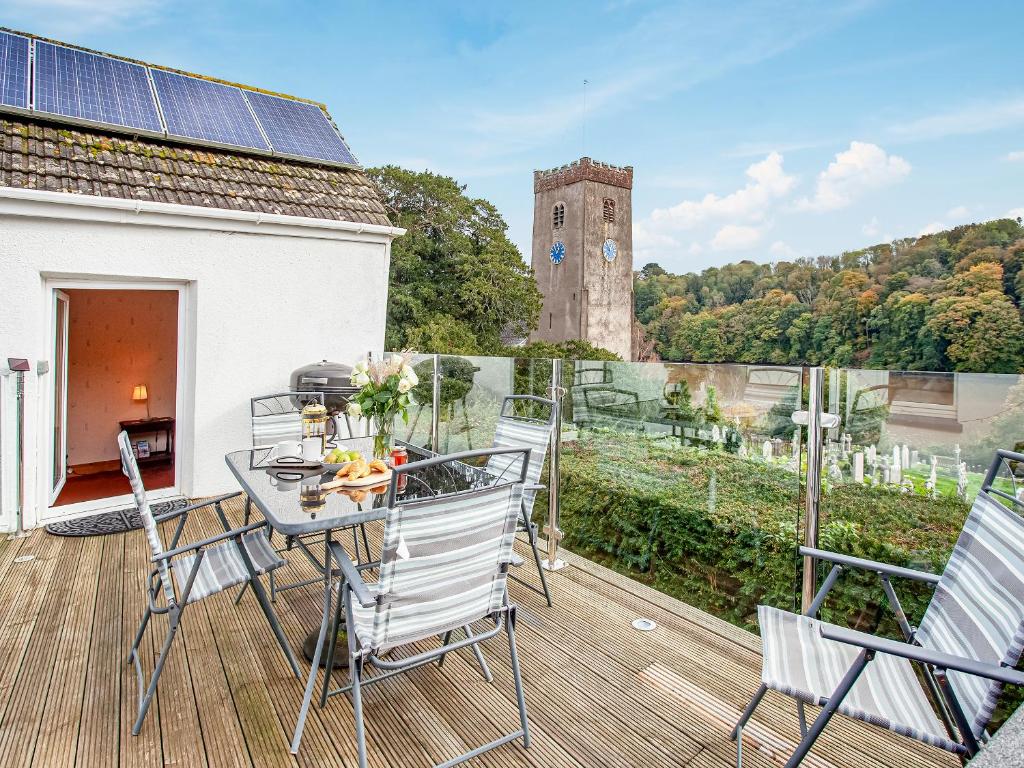 a balcony with a table and chairs and a clock tower at Barnhay Cottage in Totnes