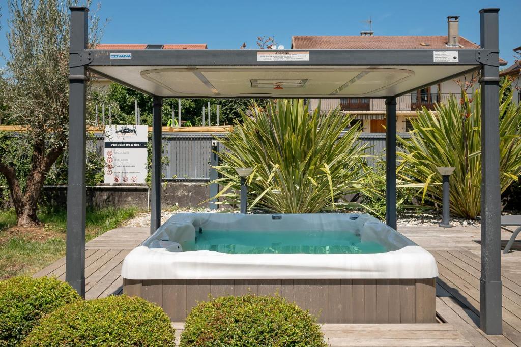a gazebo with a hot tub in a garden at La suite des Sommets in Barberaz
