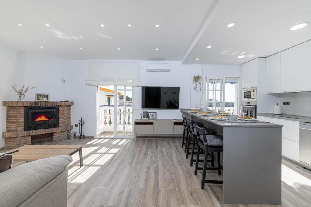 a kitchen and living room with a bar and a fireplace at Casa Jabe in Cómpeta