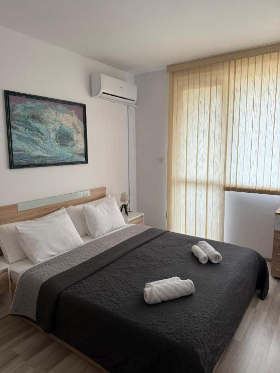 a bedroom with a large bed with two towels on it at Lucky7Lux1 in Pazardzhik