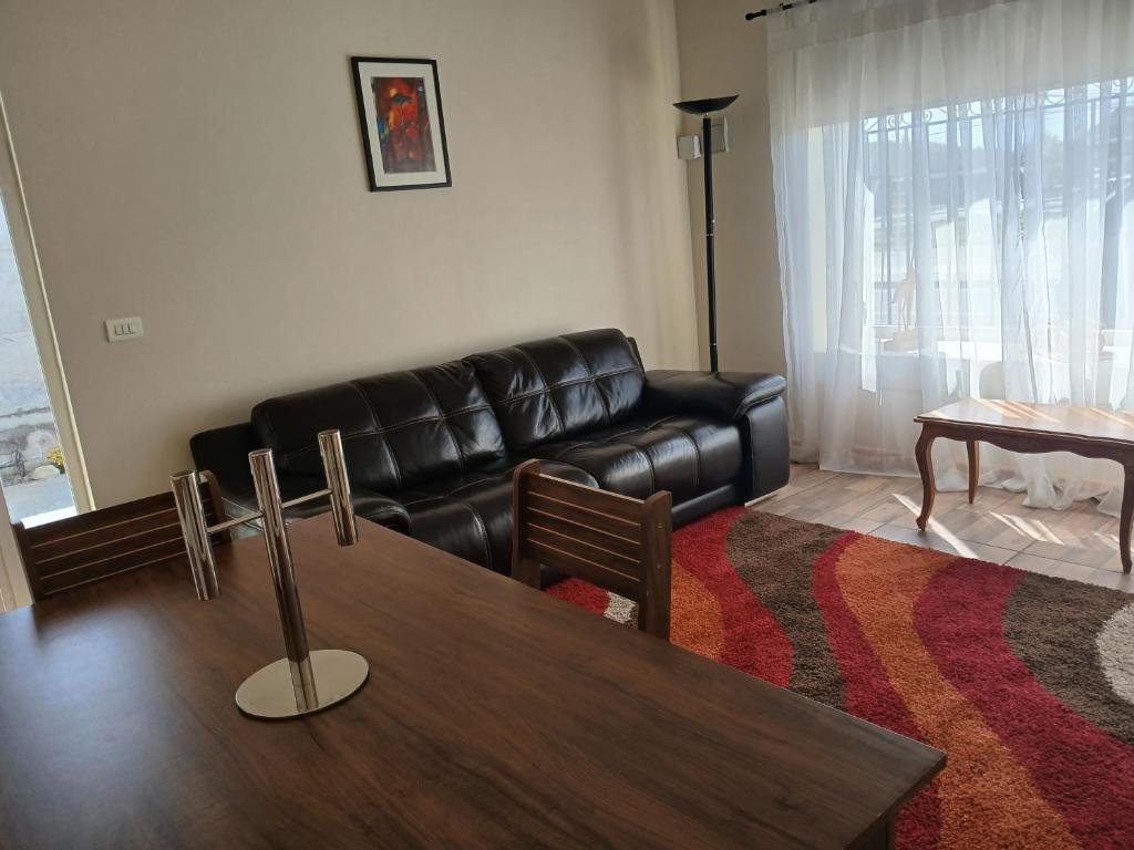 a living room with a leather couch and a table at Casa Cómoda en La Cruz Quillota in La Cruz